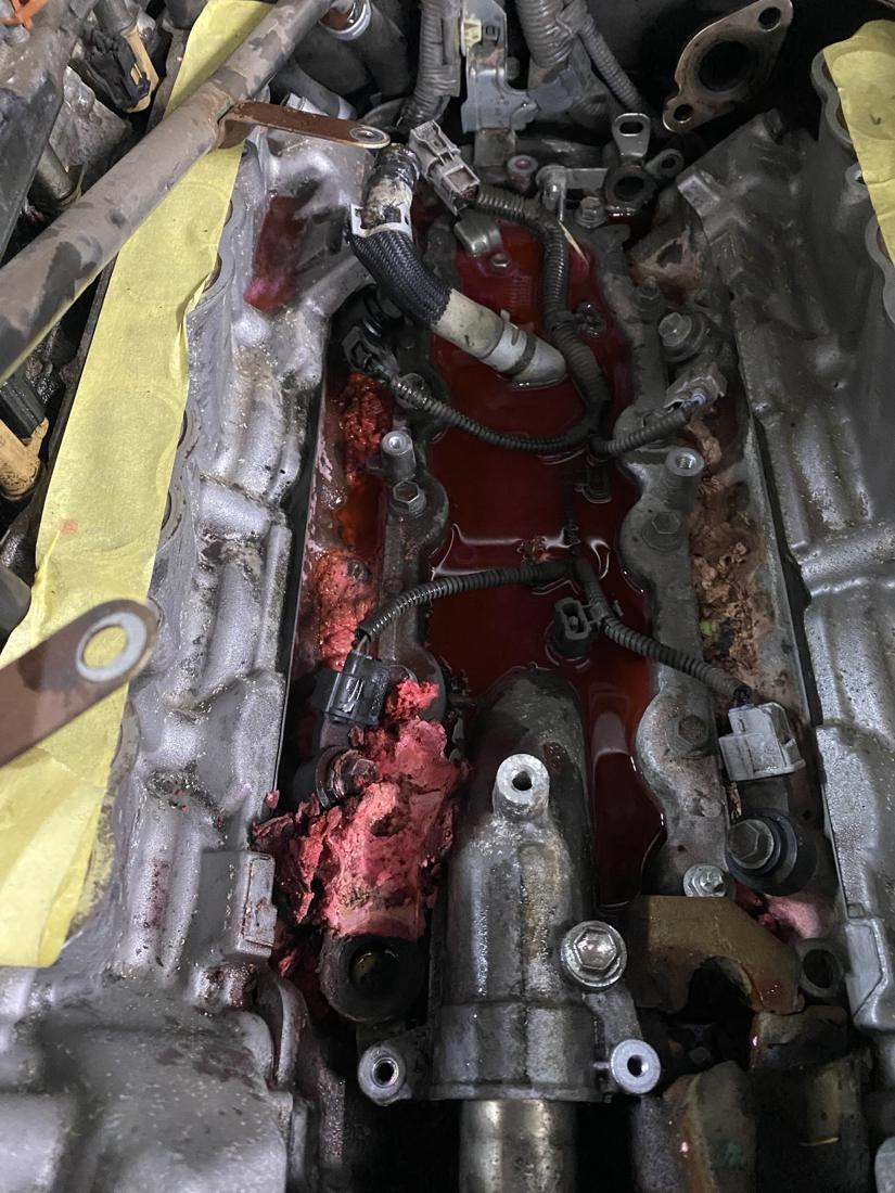 Red coolant flooding the engine valley of a GX460 with the intake manifold removed